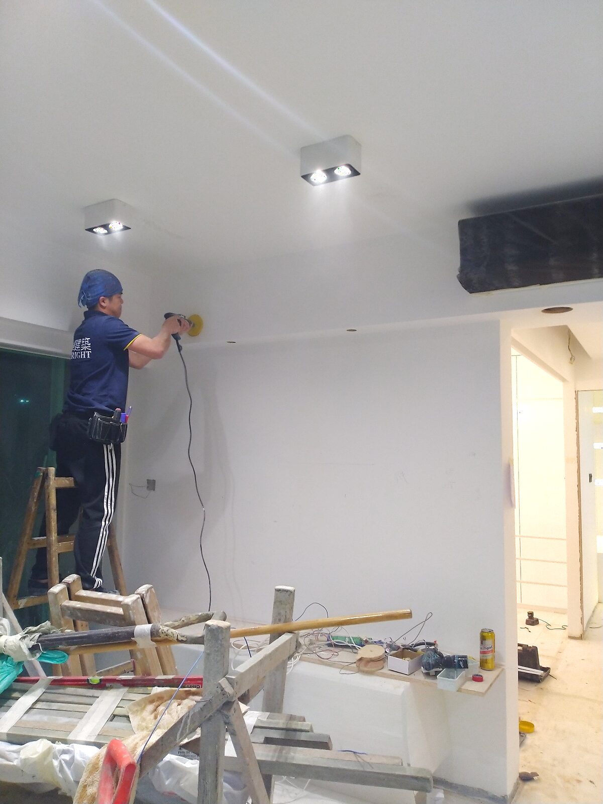 香港裝修師傅在客廳天花打磨批灰,準備油漆工序